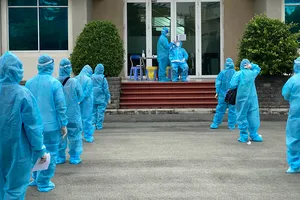 Người lao động xếp hàng chờ tầm soát Covid-19 trước khi vào sản xuất tại KCX Tân Thuận sáng 20-8. Ảnh: CAO THĂNG