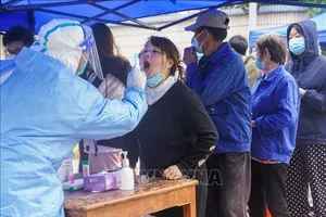 Nhân viên y tế lấy mẫu xét nghiệm cho người dân Thượng Hải ngày 26-3-2022. Ảnh: THX/TTXVN