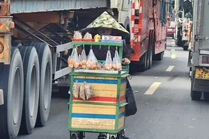 Bán hàng rong giữa làn đường xe tải