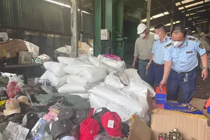 Lực lượng Quản lý thị trường TPHCM thu giữ, kiểm đếm hàng hóa giả mạo, trôi nổi trên thị trường. Ảnh: TRƯƠNG XUÂN