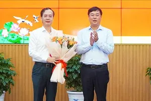 Bí thư Tỉnh ủy Đồng Tháp Lê Quốc Phong (bìa phải) trao hoa chúc mừng đồng chí Trần Trí Quang