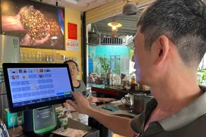 Sử dụng máy tính tiền kết nối hóa đơn điện tử tại một hộ kinh doanh ở TPHCM. Ảnh: HOÀNG HÙNG