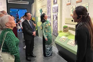 Bà Trần Thị Diệu Thúy, Phó Chủ tịch UBND TPHCM trao Cờ truyền thống của UBND thành phố cho đại diện Bảo tàng Chứng tích Chiến tranh. ẢNH: VĂN HÀ.