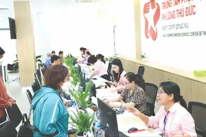 Công chức phường Thủ Đức (TPHCM) giải quyết thủ tục hành chính cho người dân. Ảnh: THU HƯỜNG