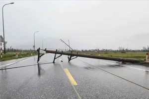 Trụ điện gãy, chắn ngang đường. Ảnh: DƯƠNG QUANG