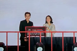 Bà Lê Thị Hồng Nhung, Phó Giám đốc Trung tâm Truyền thông - Sự kiện Báo SGGP tiếp nhận bảng trao tượng trưng 200 triệu đồng hỗ trợ đồng bào vùng bão lũ từ ông Lê Hồng Phong, Giám đốc Kinh doanh HONOR Việt Nam