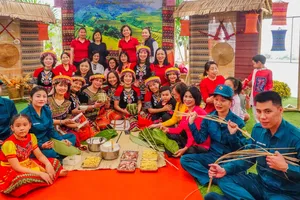 Các thầy cô giáo và lực lượng dân quân cùng tham gia gói bánh chưng. Ảnh: XUÂN QUỲNH