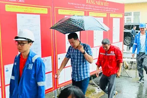 Cử tri đi bỏ phiếu trong thời tiết mưa nặng hạt tại khu vực bỏ phiếu số 1 ở Hội trường Hải đoàn 129 (phường Phước Thắng) vào sáng 26-2. Ảnh: VIỆT DŨNG