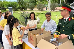 Tặng những phần quà nhỏ cho người dân và du khách viếng Bác trong ngày 30-4. Ảnh LAN HƯƠNG