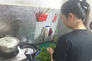 Nữ công nhân nấu bữa tối muộn sau giờ tăng ca tại phòng trọ gần khu công nghiệp Thái Nguyên. Ảnh: PHÚC HẬU 