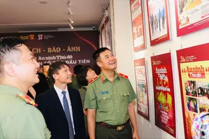 Các đại biểu tham quan khu vực trưng bày bìa báo ANTĐ. Ảnh: QUẾ VÂN