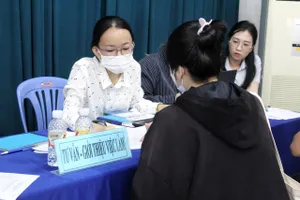 Người lao động tìm hiểu thông tin tuyển dụng tại một sàn giao dịch việc làm tổ chức tại TPHCM (ẢNH: HUỲNH NHƯ)