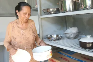 Bà Nguyễn Thị Thắm bên căn bếp mới do Hội LHPN phường Tân Thới Hiệp trao tặng (ẢNH: MẪN NHI)