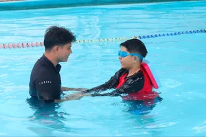 HLV Quách Văn Vinh hướng dẫn tập bơi cho một học viên (ẢNH: THƯ NGUYỄN)
