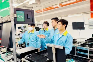 Anh Võ Anh Tuấn (bìa phải) cùng đồng nghiệp kiểm tra các bộ phận công nghệ tại Công ty TNHH Jabil Việt Nam. ẢNH: NVCC