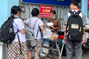 Người bán hàng rong "quên" đeo khẩu trang khi bán thực phẩm cho học sinh