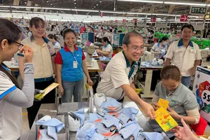 Ông Đinh Sỹ Phúc, Chủ tịch Công đoàn Công ty CP TKG Taekwang Vina, tặng lì xì cho công nhân. Ảnh: HỒNG ĐÀO