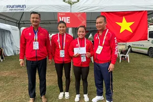 Trưởng đoàn thể thao Việt Nam tại SEA Games 33 Nguyễn Hồng Minh (bìa phải) trao thưởng nóng cho 2 tuyển thủ canoeing giành HCV đầu tiên. Ảnh: DŨNG PHƯƠNG