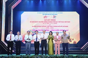 Chủ tịch HĐND TPHCM Võ Văn Minh (thứ 4 từ trái sang) và Phó Chủ tịch UBND TPHCM Trần Thị Diệu Thúy trao kỷ niệm chương tri ân đến các lãnh đạo thể thao TPHCM qua nhiều thời kỳ. Ảnh: DŨNG PHƯƠNG 