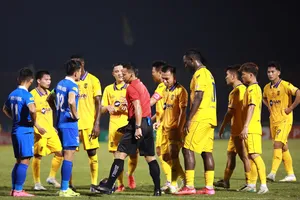 Trọng tài người Malaysia Razlan Joffri thay đổi quyết định từ phạt đền sang đá phạt ngoài vòng cấm cho SLNA. ẢNH: TÂM HÀ 