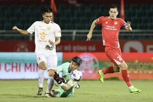 Tiền đạo Tiến Linh (áo đỏ) bị các cầu thủ Hà Tĩnh theo sát. ẢNH: DŨNG PHƯƠNG 