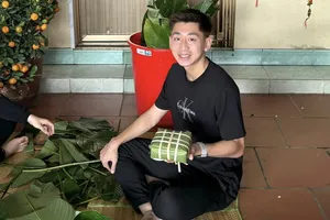 Trung vệ Nguyễn Nhật Minh gói bánh chưng cùng gia đình. ẢNH: FBNV 