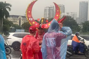 Cổ động viên “đội mưa” tiếp thêm sức mạnh cho đội tuyển Việt Nam. ẢNH: MINH HOÀNG