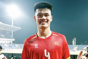 Tuyển thủ Đinh Quang Kiệt vinh dự khi được cầm cờ Việt Nam tại lễ khai mạc ASIAD 2026. ẢNH: ANH KHOA 