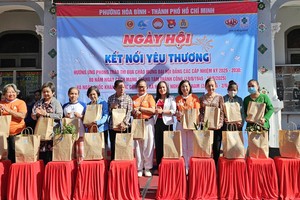 和平坊越南祖国阵线委员会副主席武氏珠向清贫户赠送礼物。