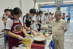 文朗学校校委主席阮曰朗观看学生烹饪比赛。