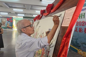 人民艺人、书画家张路在为元宵节画作题字。