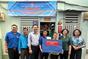 堤岸坊党委书记、坊人民议会主席黄玉女芳红（右二）向华人青年张伟泉赠送礼物。