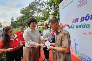 安东坊党委书记张明娇向贫困户颁发节日礼物。