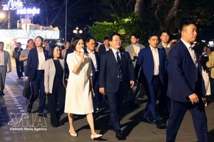 韩国总统夫人手拿冰淇淋漫步在河内街头的人群中。