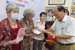 温陵会馆理事长洪世真向贫困户发放辅助金。