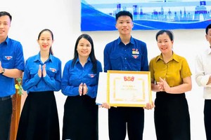 广治省共青团向黎德忠同学颁发由共青团中央授予的奖状及“勇敢青年”徽章。 图：文胜