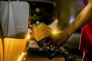 菲律宾奎松市一座加油站工作人员为车辆加注燃油。图：新华社/越通社。