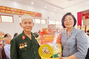 在聚会上，堤岸坊党委书记、坊人民议会主席黄玉女芳红向华人革命有功者陆兴赠送礼物。 图：心雨
