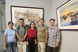 华人画家在人民艺人张路画作合照。图：心雨