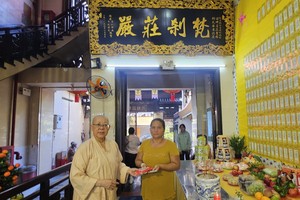 观音精舍监院释振净（悟净）法师向贫困户派发生活辅助费。图：心雨