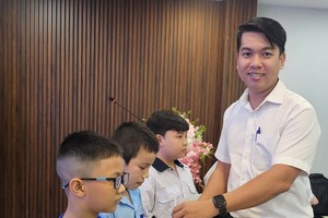 胡志明市越南祖国阵线委员会社会工作处副主任刘平龙向小学生颁发助学金。图：心雨