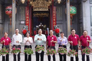 堤岸坊领导向义安会馆赠送各种绿色植物花篮。图：心雨