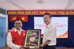 胡志明市红十字会主席阮明日向中国共产党中央社会工作部副部长赵世堂赠送礼物。图：心雨