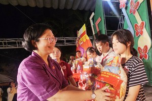 堤岸坊党委书记黄玉女芳红向贫困子弟赠送礼物。图：心雨