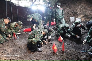 K74队干部、战士在刚发现的烈士集体墓区域展开烈士遗骸搜寻、归集工作。图自越通社