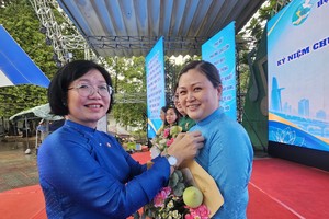 坊党委书记黄玉女芳红向华人妇女吳丽株颁发纪念章。图：心雨