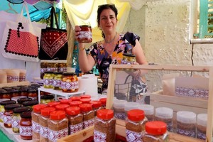 一位女士展示自制果酱。（图取自人民网）