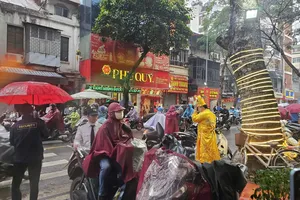 Người dân chờ mua vàng bất chấp trời Hà Nội sáng nay mưa. Ảnh: LƯU THỦY