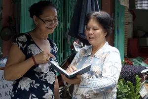 Bí thư chi bộ đồng thời là Trưởng khu phố 4, phường 1, quận 3  Nguyễn Thị Chiếm (bên phải) trao đổi với người dân trong khu phố