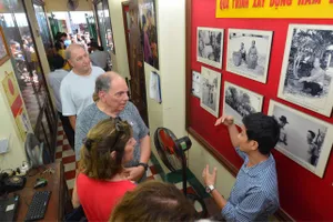 Du khách nước ngoài nghe giới thiệu về lực lượng  Biệt động Sài Gòn. Ảnh: VIỆT DŨNG